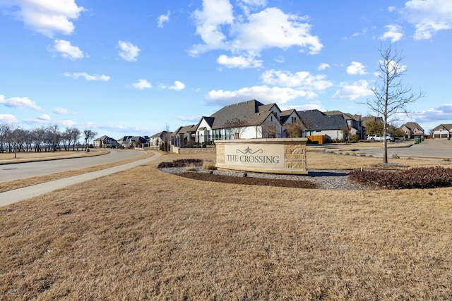 community / neighborhood sign featuring a residential view and a yard