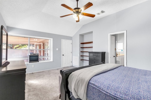 carpeted bedroom with visible vents, a ceiling fan, connected bathroom, lofted ceiling, and a textured ceiling