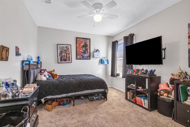 bedroom featuring ceiling fan, a textured ceiling, light carpet, visible vents, and baseboards