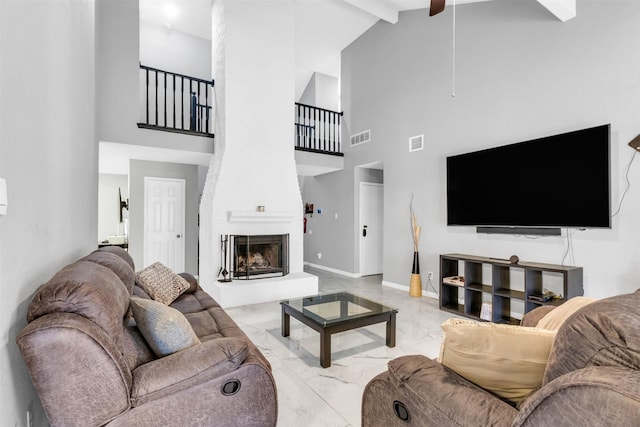 living room with a large fireplace, marble finish floor, visible vents, and baseboards