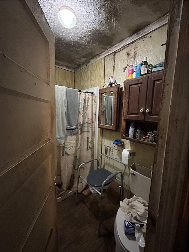 full bathroom featuring curtained shower, a textured ceiling, and toilet