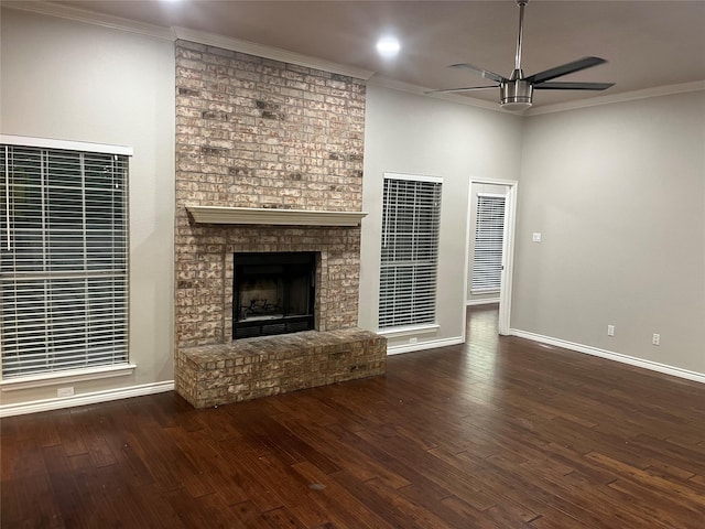 unfurnished living room with dark wood-style floors, ornamental molding, and a brick fireplace