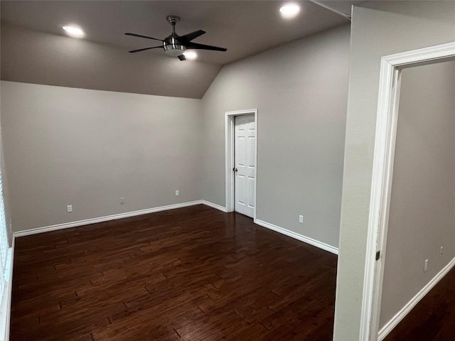 spare room with lofted ceiling, ceiling fan, dark wood-type flooring, and baseboards