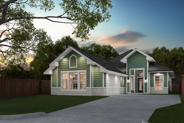 view of front of home with a yard, concrete driveway, an attached garage, fence, and stone siding