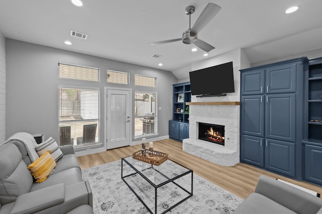 living area with a stone fireplace, light wood finished floors, visible vents, and recessed lighting