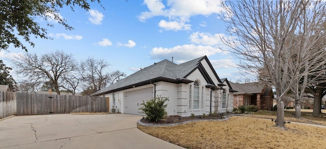 view of side of home with driveway, an attached garage, and fence