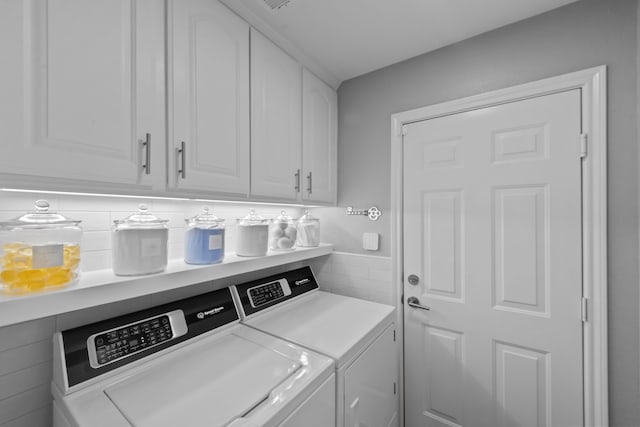 washroom with cabinet space and separate washer and dryer