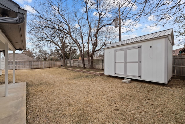 view of yard featuring a shed, a fenced backyard, and an outdoor structure