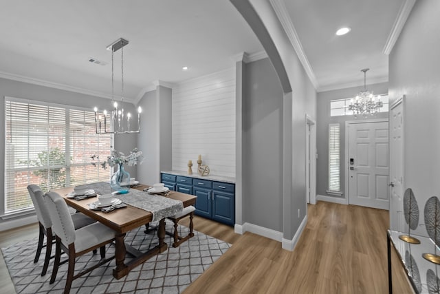 dining space featuring arched walkways, plenty of natural light, a chandelier, and crown molding