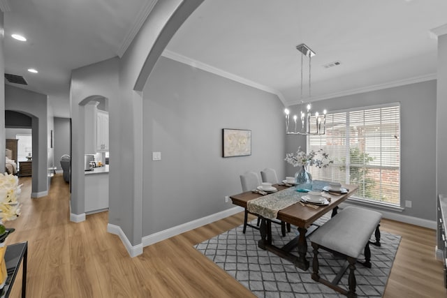 dining room featuring arched walkways, visible vents, and crown molding