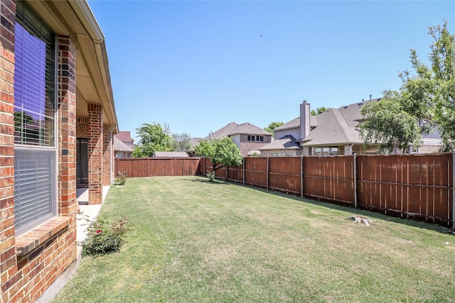view of yard with a fenced backyard and a residential view