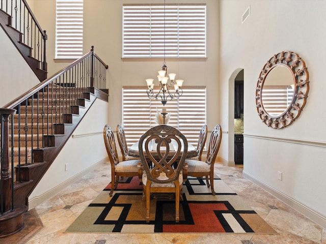 2728 Village Creek St, Celina, TX 75078 - dining space featuring visible vents, stairway, arched walkways, a high ceiling, and a notable chandelier