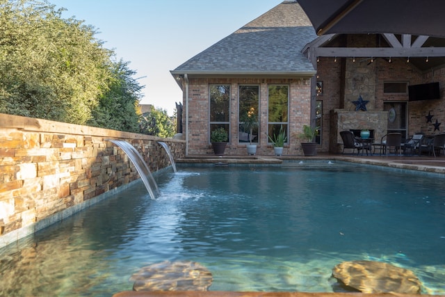 view of swimming pool featuring an outdoor stone fireplace and a patio area