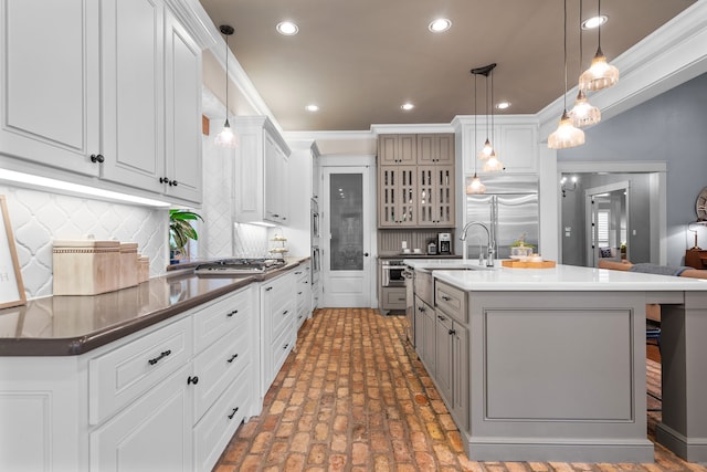 kitchen featuring stainless steel appliances, dark countertops, hanging light fixtures, glass insert cabinets, and white cabinets