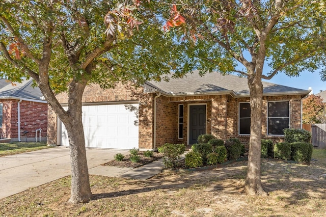 ranch-style home with a garage, brick siding, a shingled roof, fence, and concrete driveway