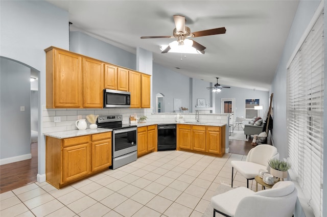 kitchen with stainless steel appliances, a peninsula, a sink, lofted ceiling, and ceiling fan