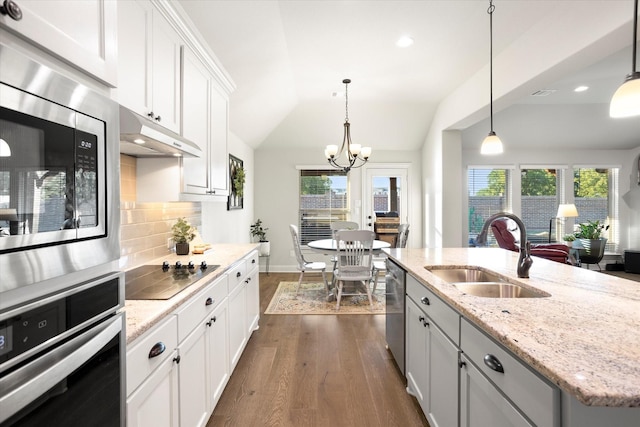 kitchen with white cabinets, an island with sink, appliances with stainless steel finishes, pendant lighting, and a sink