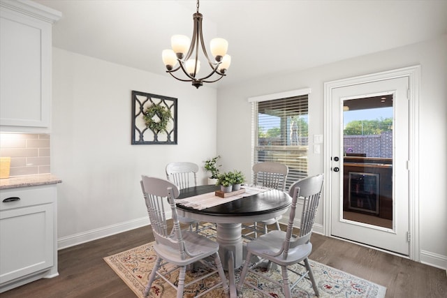 dining space with a notable chandelier, baseboards, and dark wood-type flooring