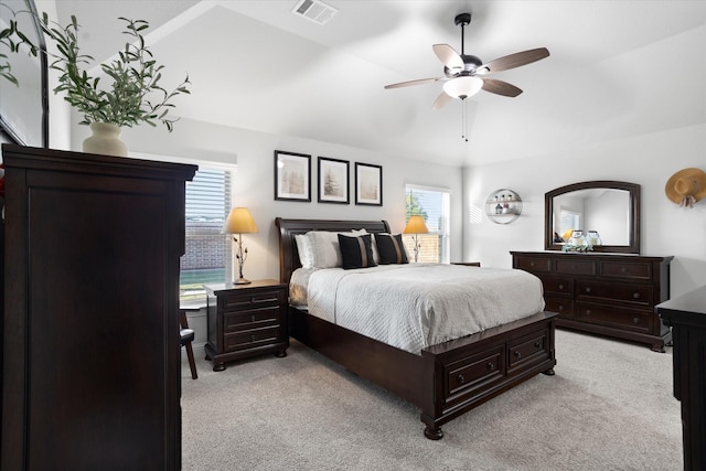 bedroom featuring light carpet, visible vents, and multiple windows