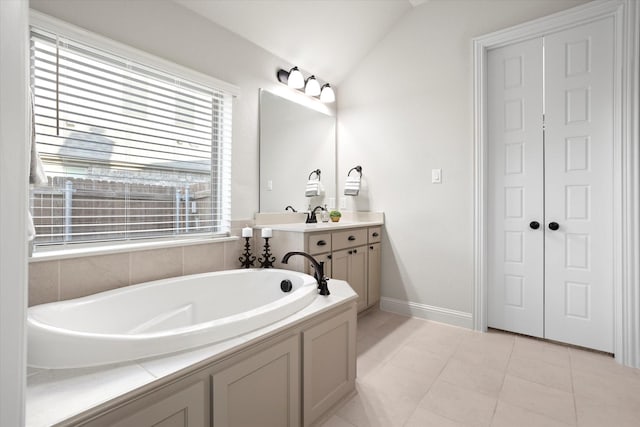 bathroom with lofted ceiling, tile patterned flooring, vanity, baseboards, and a bath