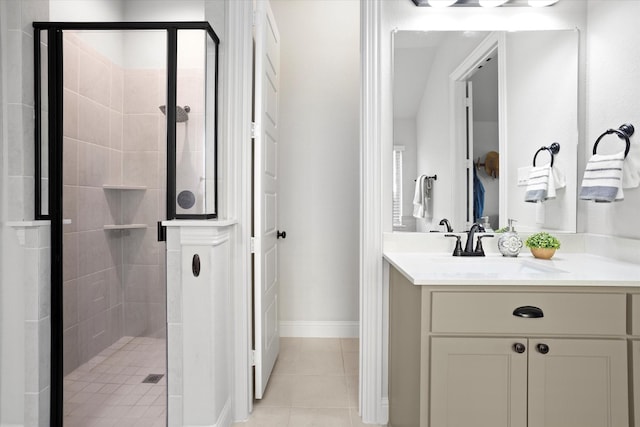 bathroom featuring a stall shower, vanity, baseboards, and tile patterned floors