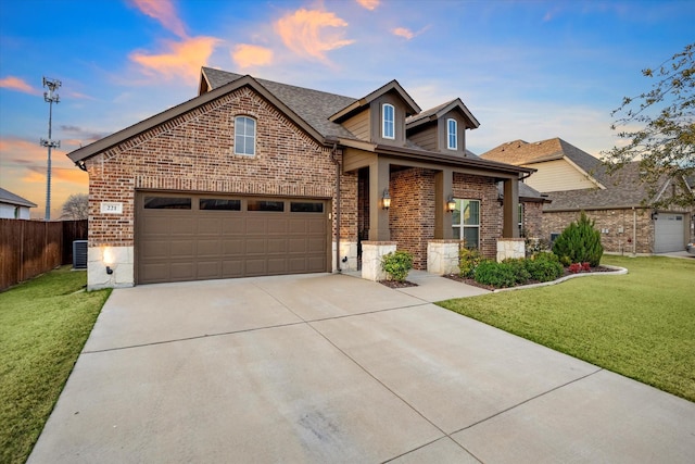 view of front of house featuring a yard, brick siding, driveway, and fence