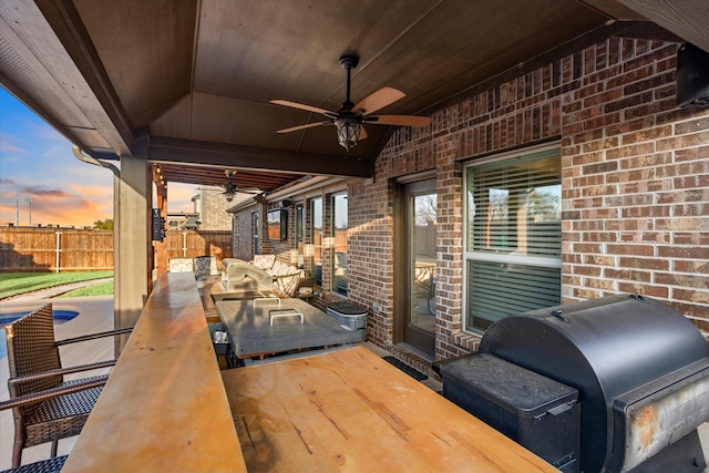 view of patio / terrace with ceiling fan, area for grilling, and fence