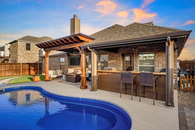 view of swimming pool featuring a patio area, fence, outdoor dry bar, and a fenced in pool