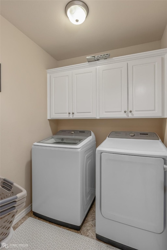 laundry room featuring separate washer and dryer and cabinet space