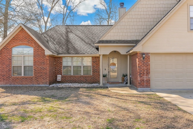 view of front of house with a shingled roof, a front yard, and brick siding