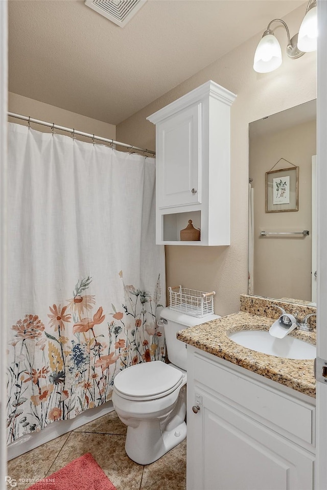 full bathroom with visible vents, vanity, toilet, and tile patterned floors