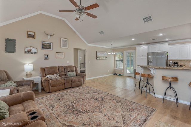 living area featuring light wood-type flooring, visible vents, and crown molding