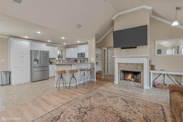 kitchen with white cabinets, stainless steel appliances, a breakfast bar, and open floor plan