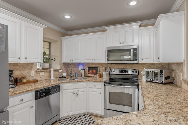 kitchen featuring white cabinetry, appliances with stainless steel finishes, a sink, and ornamental molding