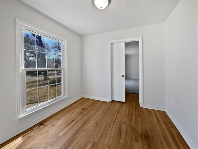 empty room with light wood-type flooring and baseboards