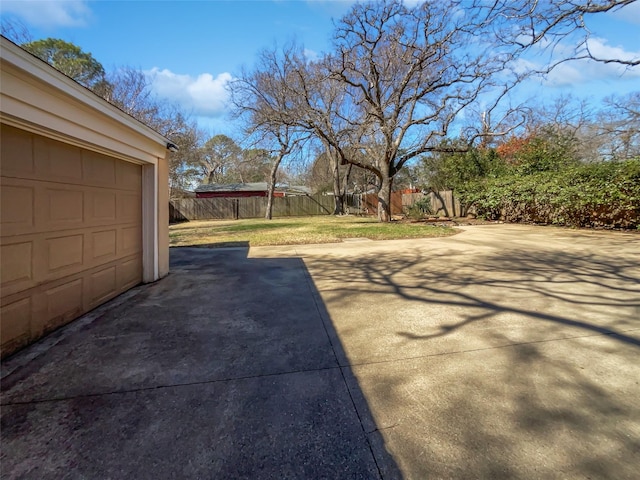 view of yard featuring a garage and fence