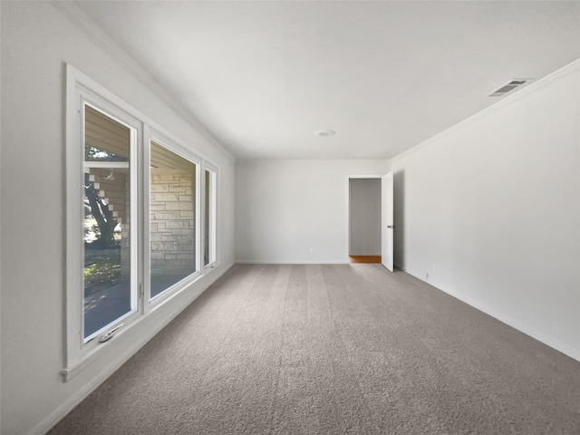 carpeted spare room with visible vents and crown molding