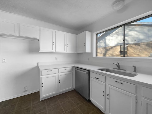 kitchen featuring white cabinets, light countertops, a sink, and stainless steel dishwasher