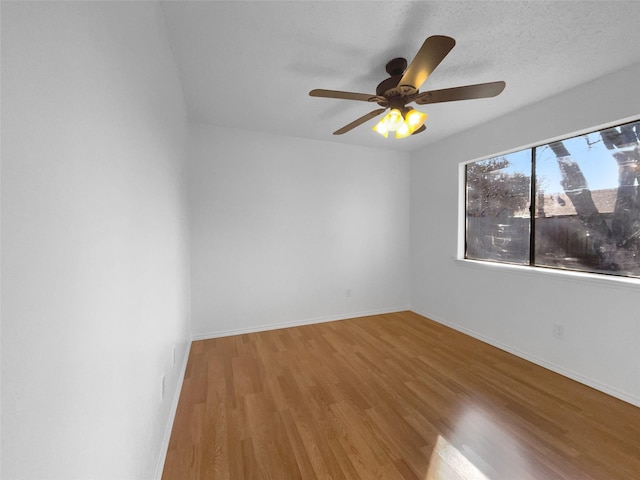 empty room with ceiling fan, baseboards, and wood finished floors