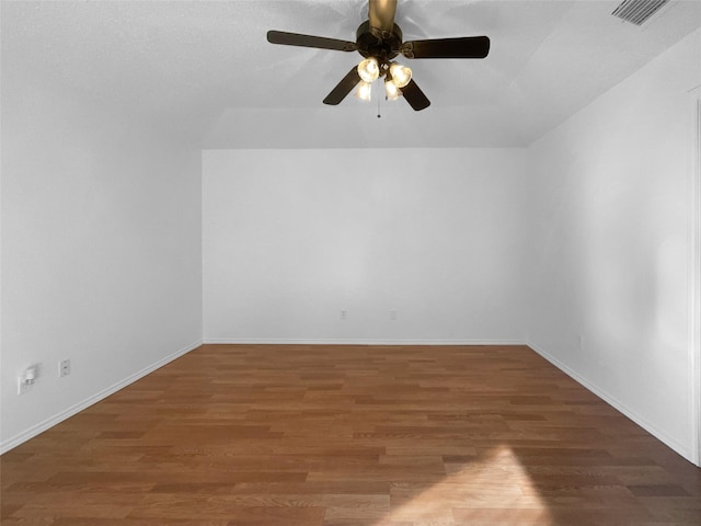 unfurnished room with dark wood-style floors, baseboards, visible vents, and a ceiling fan