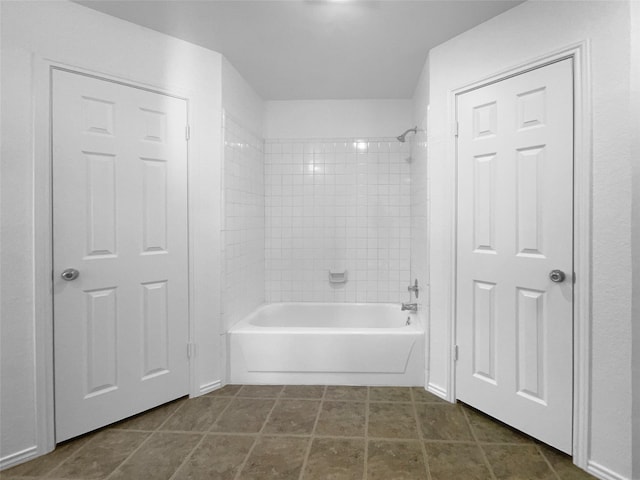 bathroom featuring tile patterned flooring and washtub / shower combination