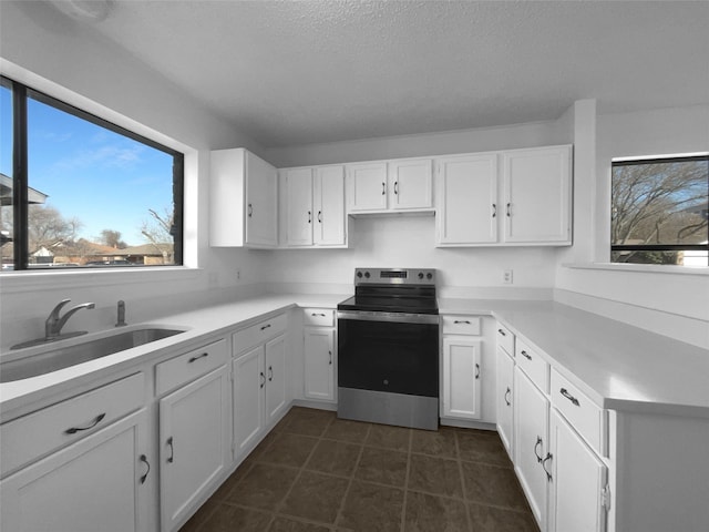 kitchen with white cabinetry, stainless steel electric stove, and light countertops