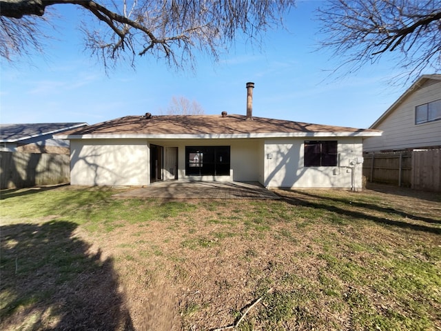 back of house featuring fence, a patio, and a lawn