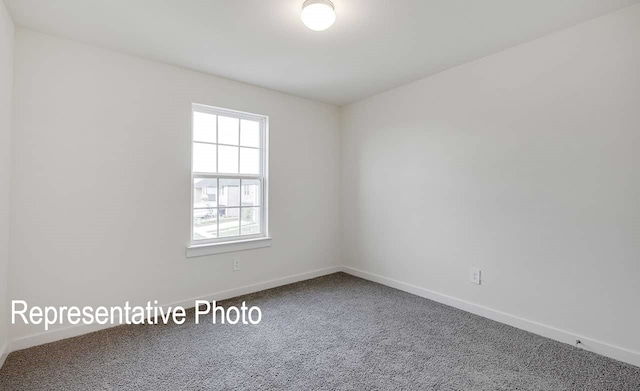 unfurnished room featuring carpet floors and baseboards