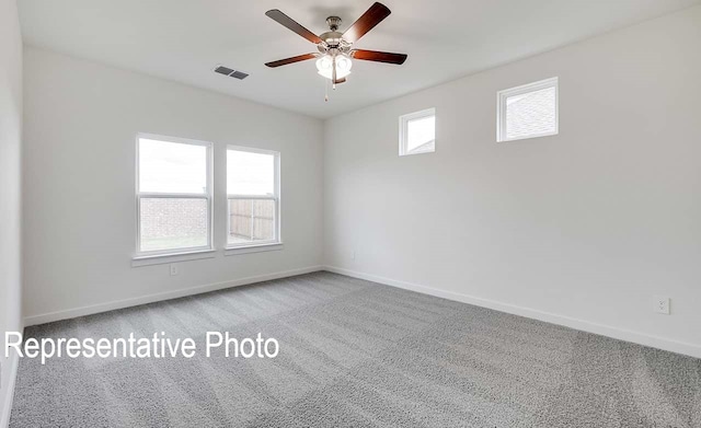 unfurnished room featuring ceiling fan, carpet floors, visible vents, and baseboards