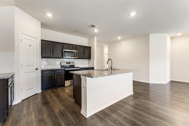 1023 Bedias Rd, Forney, TX 75126 - kitchen featuring dark wood-style flooring, a sink, visible vents, appliances with stainless steel finishes, and an island with sink