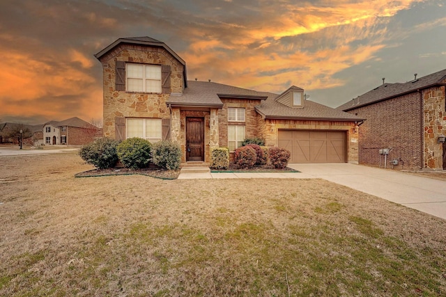 view of front of home featuring driveway, stone siding, a garage, and a yard