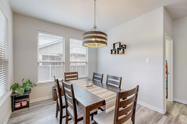 dining area featuring baseboards, a chandelier, and light wood-style floors