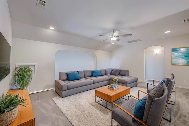 living room with arched walkways, visible vents, vaulted ceiling, and carpet