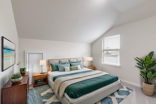 bedroom with carpet floors, baseboards, and lofted ceiling